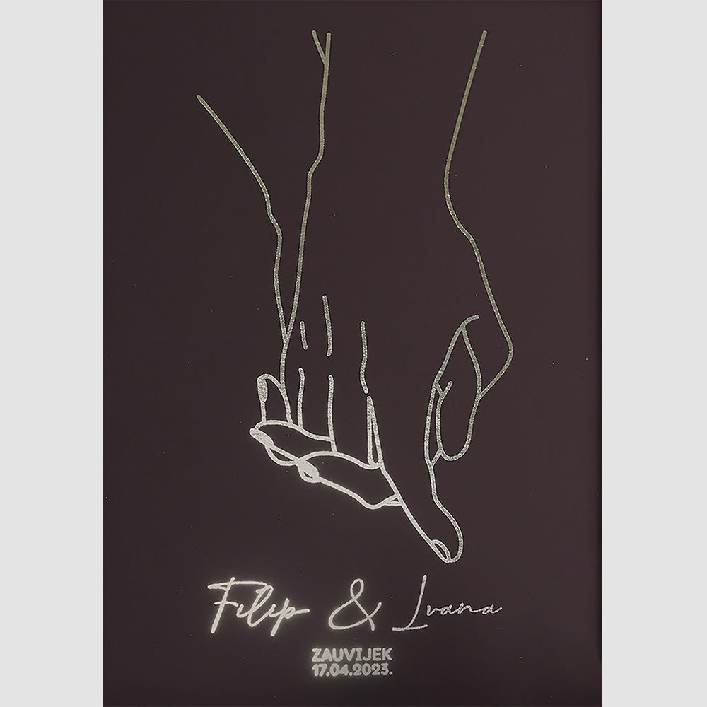 obris para koji se drži za ruke s metalnom folijom