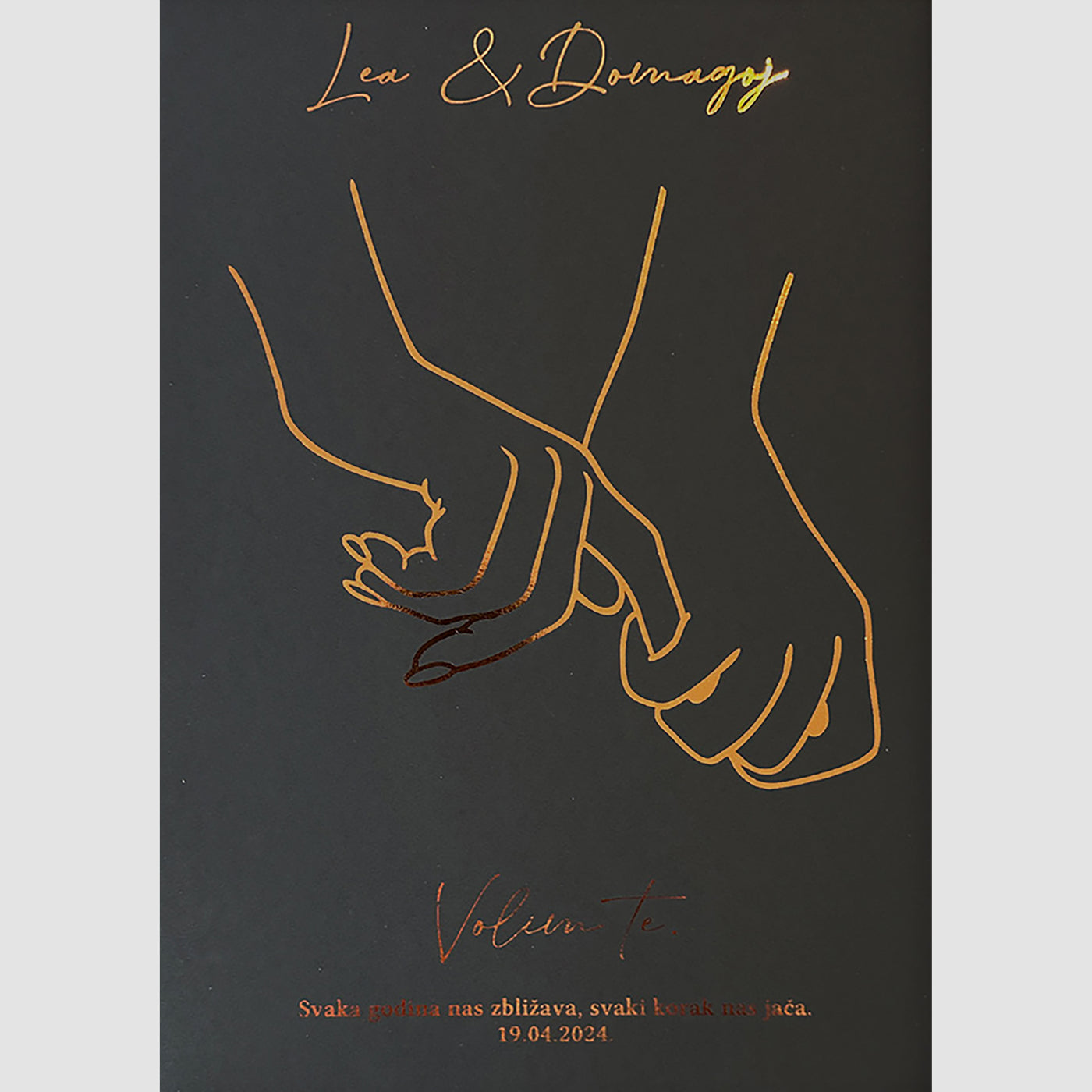 zaljubljeni par koji se drži za ruke. s imenima i posvetom i metalnom folijom